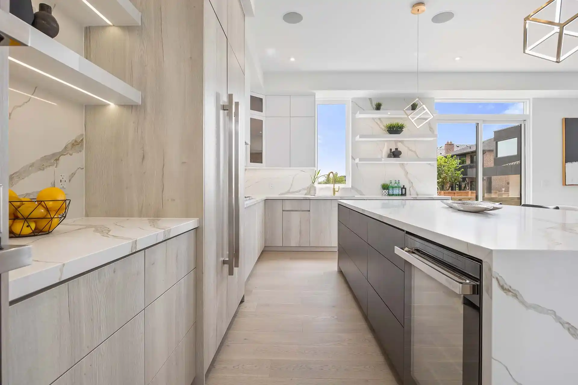 Kitchen with a marble island, integrated appliances and a garden view