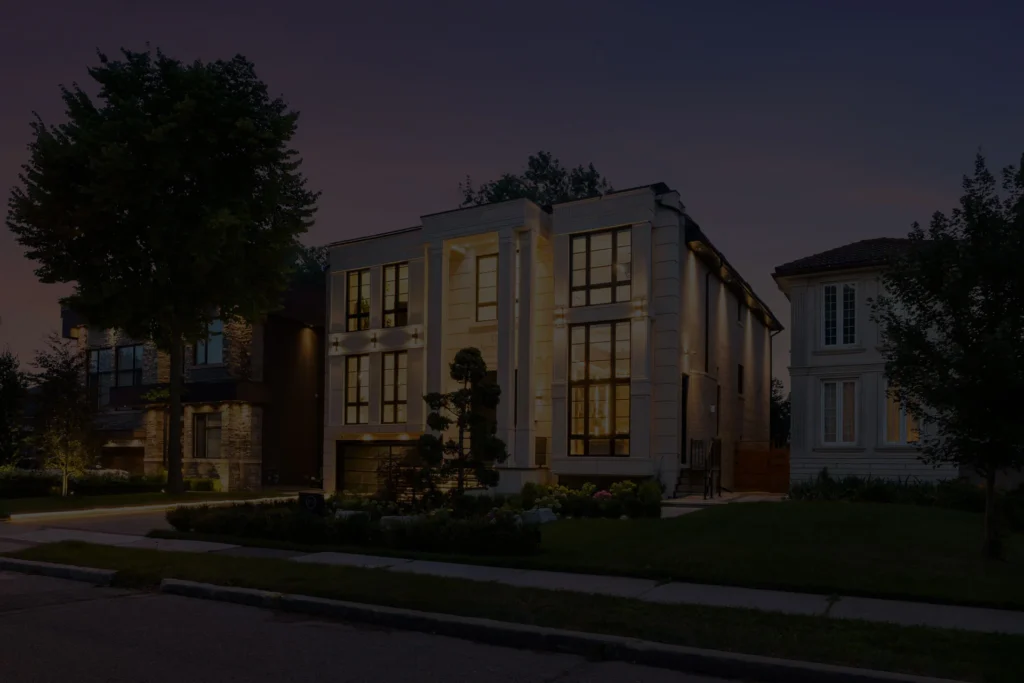 Twilight exterior of a modern detached home in the Greater Toronto Area, windows glowing against a dusk sky