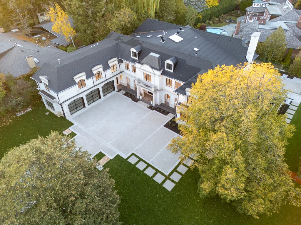 Aerial view of a detached property showing the roofline, grounds and surrounding street