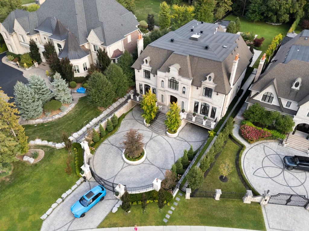 Aerial frame showing a house, its driveway and mature trees