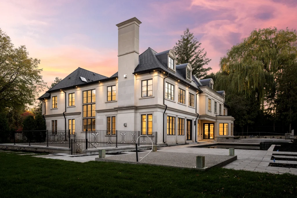 Exterior of a home at dusk with interior lights on and a deep blue sky