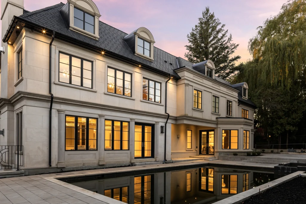 Front elevation of a home at twilight with warm window light